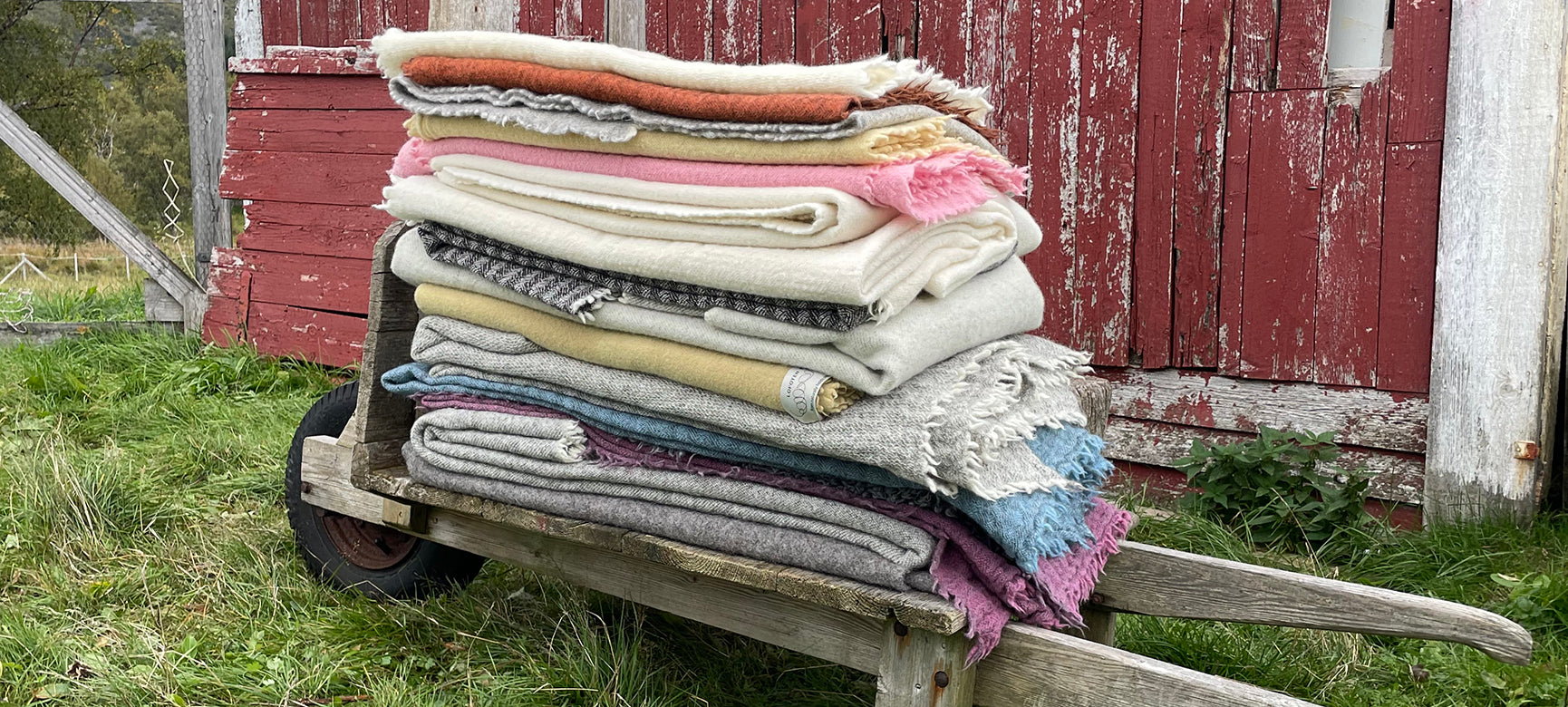 a pile of woolen textiles on and old wheelbarrow